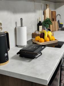 a kitchen counter with a juicer and a bowl of fruit at Prikas Apartments B in Kefalos +6 photos