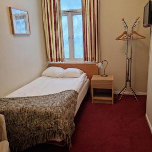 a hotel room with a bed and a window at Hotell S:t Olof in Falköping