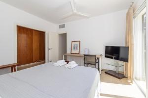 a bedroom with a bed and a desk and a tv at Biniancolla Ginesta in Biniancolla
