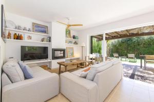 a living room with two white couches and a tv at Biniancolla Ginesta in Biniancolla