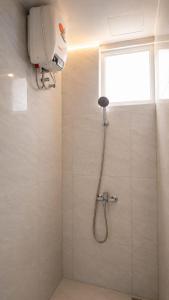 a shower with a shower head in a bathroom at Merryland ICE BSD City in Tjilandak