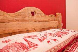 - un lit avec une tête de lit en bois et une couverture dans l'établissement Cottage Casa Felice, à Clusone