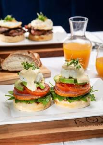 a white plate with sandwiches on a table with drinks at Terra Nova Suites and Spa in Gqeberha
