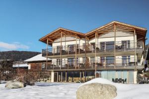 a large building with a deck in the snow at Leierhof Wicky in Rodengo