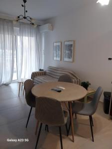 a living room with a table and chairs and a couch at Menidi Sea View 302 in Menídion +14 photos