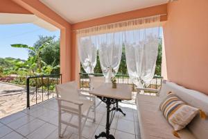a room with a balcony with a table and chairs at Sivotahomes - Noah in Syvota