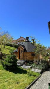 a wooden house with a roof on a green field at Haus Monica in Bodenmais
