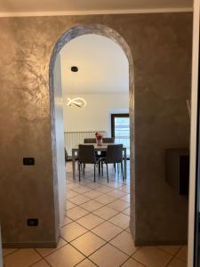 an archway leading into a dining room with a table at Appartamento la rosa in Marone +4 photos