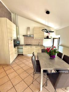 a kitchen with a table and chairs in a room at Appartamento la rosa in Marone