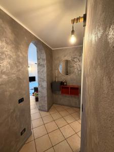 a hallway with a bathroom with a sink and a mirror at Appartamento la rosa in Marone