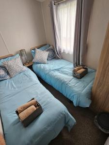 two beds in a room with blue sheets at Iris - D6 in Eyemouth