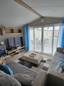 a living room with a couch and a large window at Iris - D6 in Eyemouth