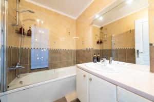 a bathroom with a sink and a shower and a tub at Warm cocoon - parking included in Asnières-sur-Seine