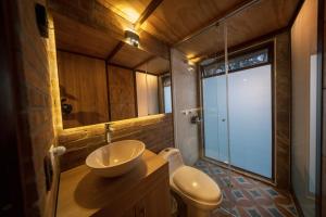 a bathroom with a sink and a toilet and a mirror at Las Cabañas La Libertad in Macanal
