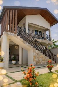 a house with a balcony and stairs at Casa Leo in Agboogba