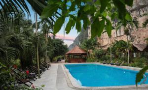 a swimming pool with chairs and a building at Tràng An Valley Garden in Ninh Binh