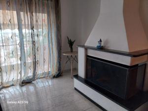 a living room with a fireplace and a window at Menidi apartment 202 in Menídion