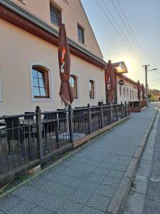 a fence with an umbrella next to a building at Penzion Borlitz in Pohořelice +28 photos