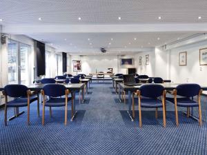 a room with rows of tables and chairs at Mercure Hotel am Entenfang Hannover in Hannover