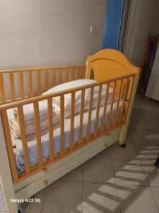 a wooden crib in a room at Menidi apartment 202 in Menídion