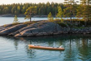 a canoe sitting in the water next to an island at Villa Korsman in Hanko