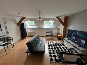 a living room with a couch and a tv at Stadtloft am Schillerpark in Dessau