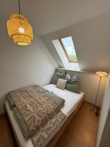 a small bedroom with a bed with a window at Stadtloft am Schillerpark in Dessau