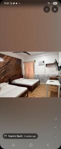 a room with two beds and a table at Yasmin's Transient House in Pagudpud