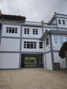 a large white building with a driveway at Yasmin's Transient House in Pagudpud