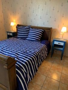 a bedroom with a bed with two nightstands and two tables at Gîte Le Mailloux - Maison calme à 15 min du Pal in Saligny-sur-Roudon