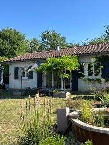 a small white house with a yard with a tree at ATELIER Gîte Cahors in Pradines
