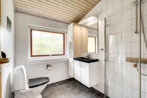 a bathroom with a toilet and a window at Skovvang 80 in Nørre Nebel +14 photos