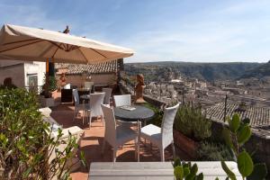 a patio with a table and chairs and an umbrella at Casa Diva in Matera