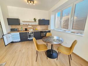 a kitchen and dining room with a table and chairs at Apartmán KVETINKA v centre Žiliny s KAVIARŇOU in Žilina +28 photos