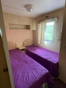 two beds in a small room with purple sheets at Valterkrasti in Ogureckaja