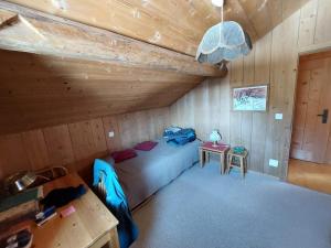 a room with a bed and a table in a cabin at Stilvolle 3,5 Dachwohnung "Alpenblick" in Davos