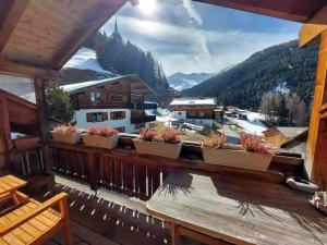 a balcony with several potted plants on a ledge at Stilvolle 3,5 Dachwohnung "Alpenblick" in Davos
