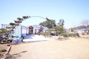 a home with an arch in front of a house at Mongsanpo High Beach Pension in Taean