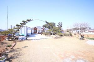 a house with an arch in the middle of a yard at Mongsanpo High Beach Pension in Taean