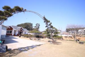 a palm tree arch in front of a house at Mongsanpo High Beach Pension in Taean +43 photos