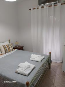 a bedroom with a bed with white towels on it at Menidi Apartment 201 in Menídion +2 photos