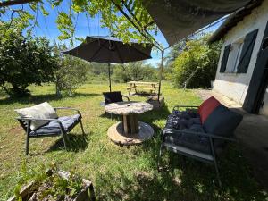 a patio with a table and chairs and an umbrella at ATELIER Gîte Cahors in Pradines