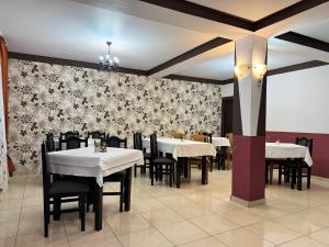 a dining room with white tables and black chairs at Casa Lupascu in Vatra Dornei