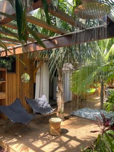 a patio with two chairs under a pergola at Tiny du lagon in Saint-Paul