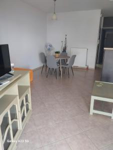 a living room with a table and chairs and a tiled floor at Menidi Apartment 201 in Menídion