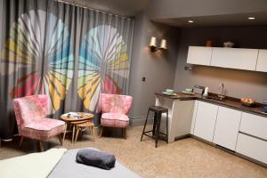 a room with two chairs and a table and a kitchen at Archavon Luxury Studio in St. Just