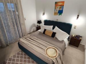 a bedroom with a large bed with a blue headboard at Prikas Apartments A in Kefalos