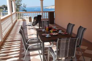 una mesa y sillas en un balcón con vistas al océano en Olive House, en Šimuni