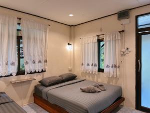 a bedroom with a bed with two pillows on it at Khao Sok Jungle Huts Resort in Khao Sok National Park