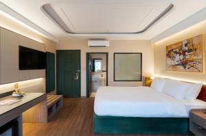 a hotel room with a bed and a television at NiK Hotel Thi Sach in Ho Chi Minh City
